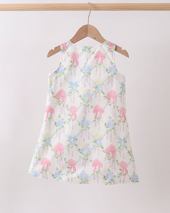 Floral dress with pink and blue flowers on a hanger against a white background