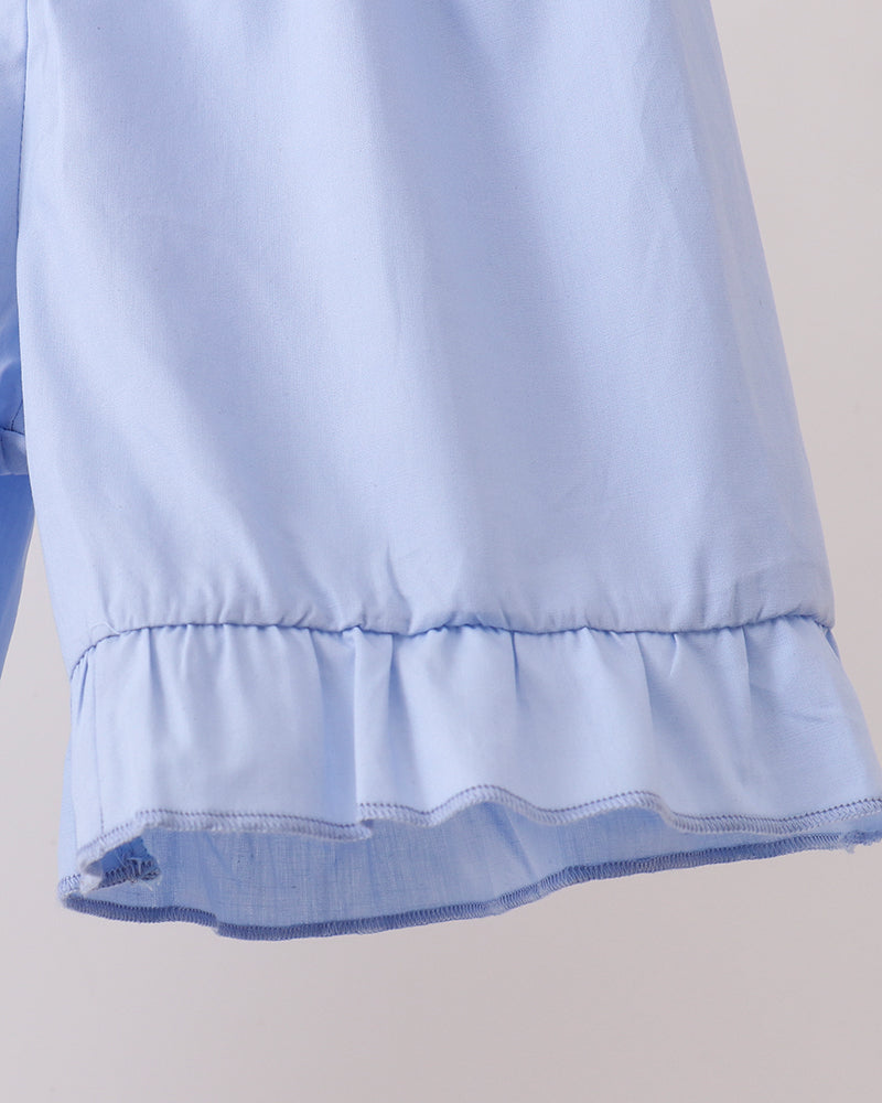 Light blue fabric with ruffled hem on a neutral background