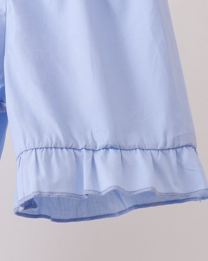Light blue fabric with ruffled hem on a neutral background