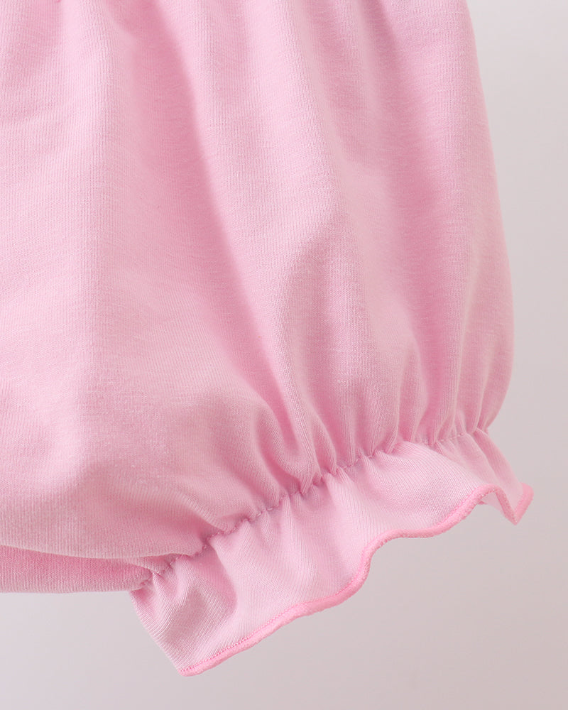 Close-up of a pink fabric with gathered waist on a light gray background