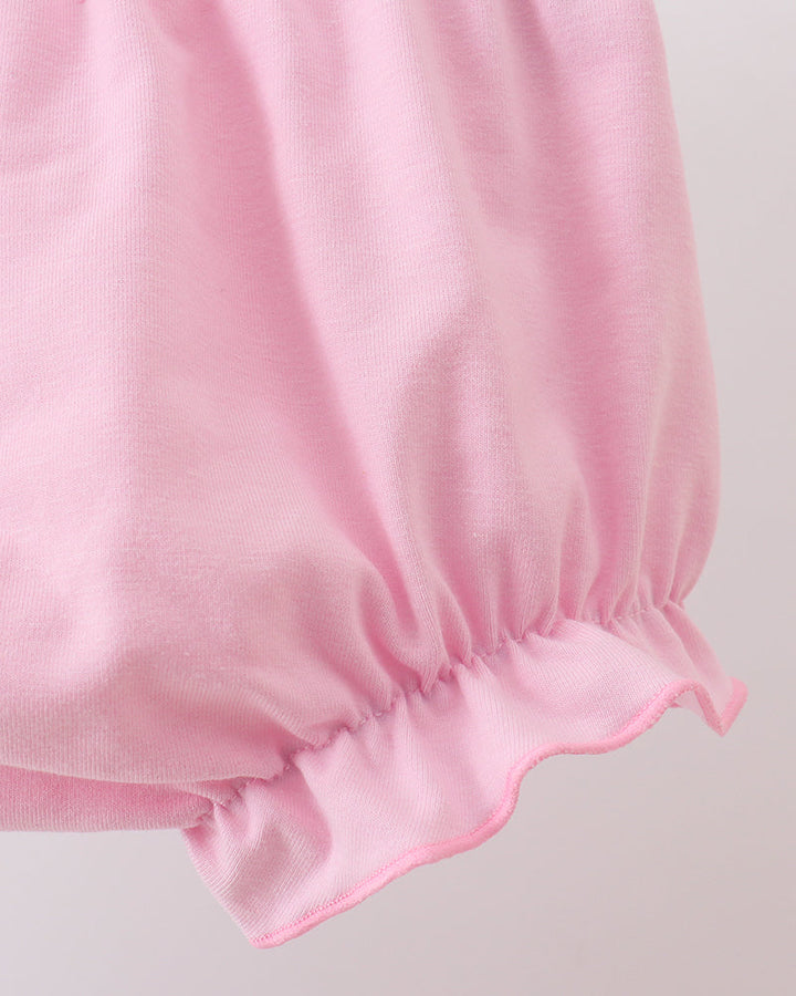 Close-up of a pink fabric with gathered waist on a light gray background