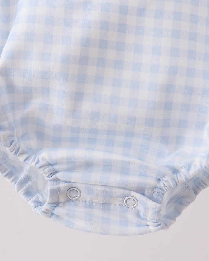 Light blue gingham bubble romper with snap buttons and gathered leg openings