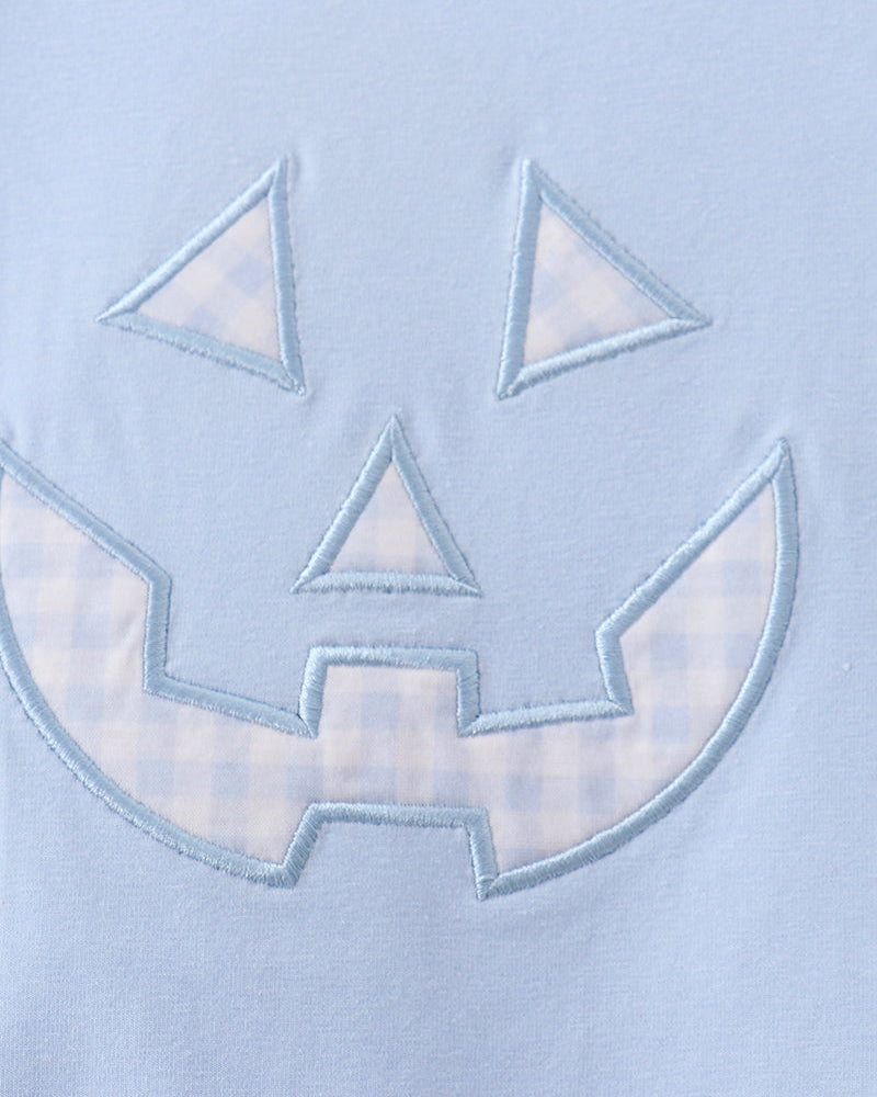 Light blue romper with stitched jack-o-lantern face applique detail
