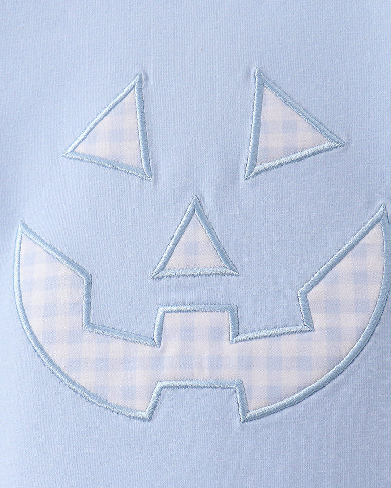 Light blue T-shirt front with stitched jack-o-lantern applique face in pale blue