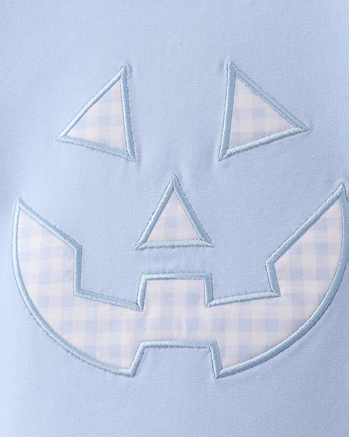 Light blue T-shirt front with stitched jack-o-lantern applique face in pale blue