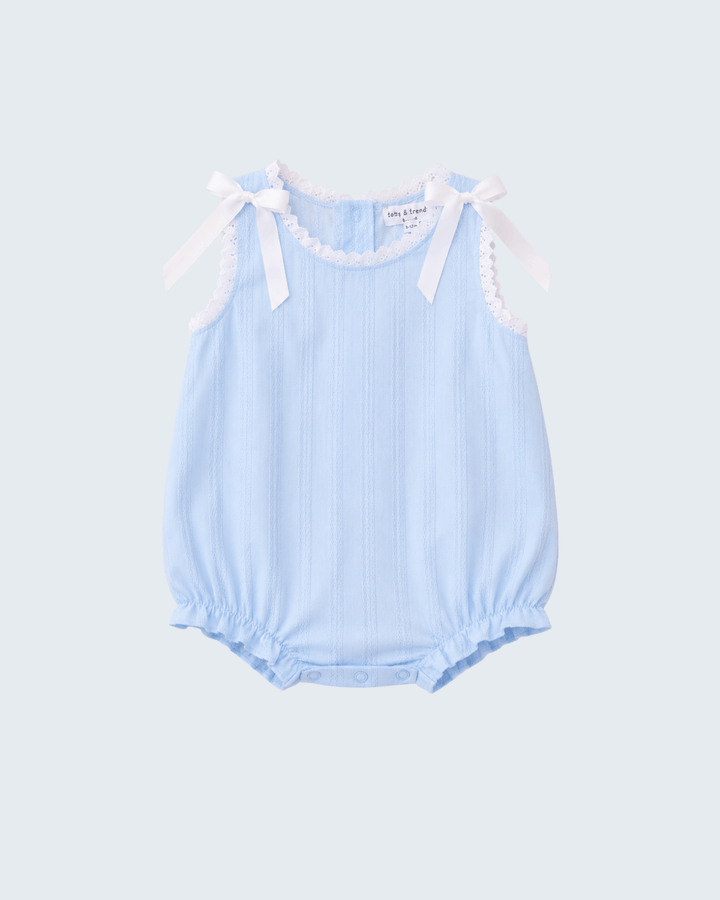 A light blue sleeveless baby romper with vertical ruffles, scalloped trim, and white ribbon bows at the shoulders, shown against a light gray background.