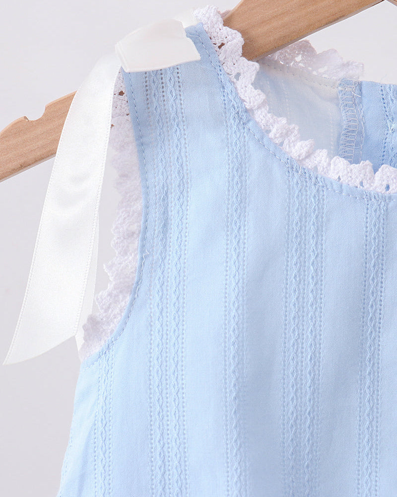 A light blue sleeveless dress with white lace trim and a white ribbon bow, hanging on a wooden hanger against a light gray background.