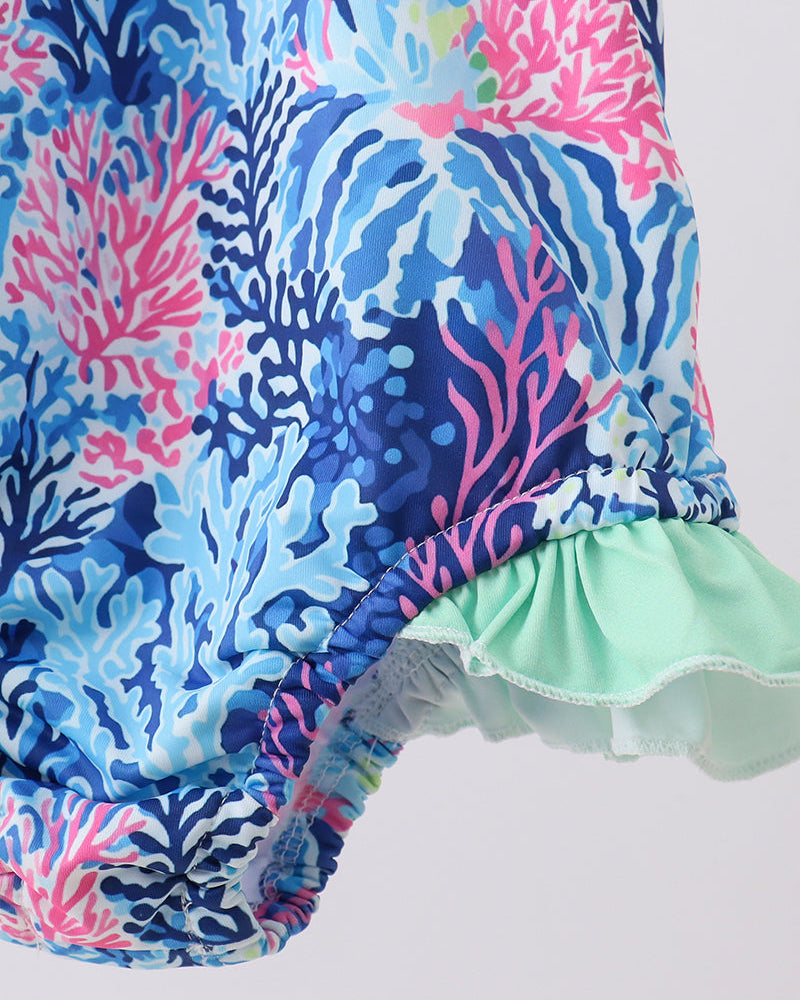 Colorful coral-patterned swimsuit with a ruffled hem on a white background