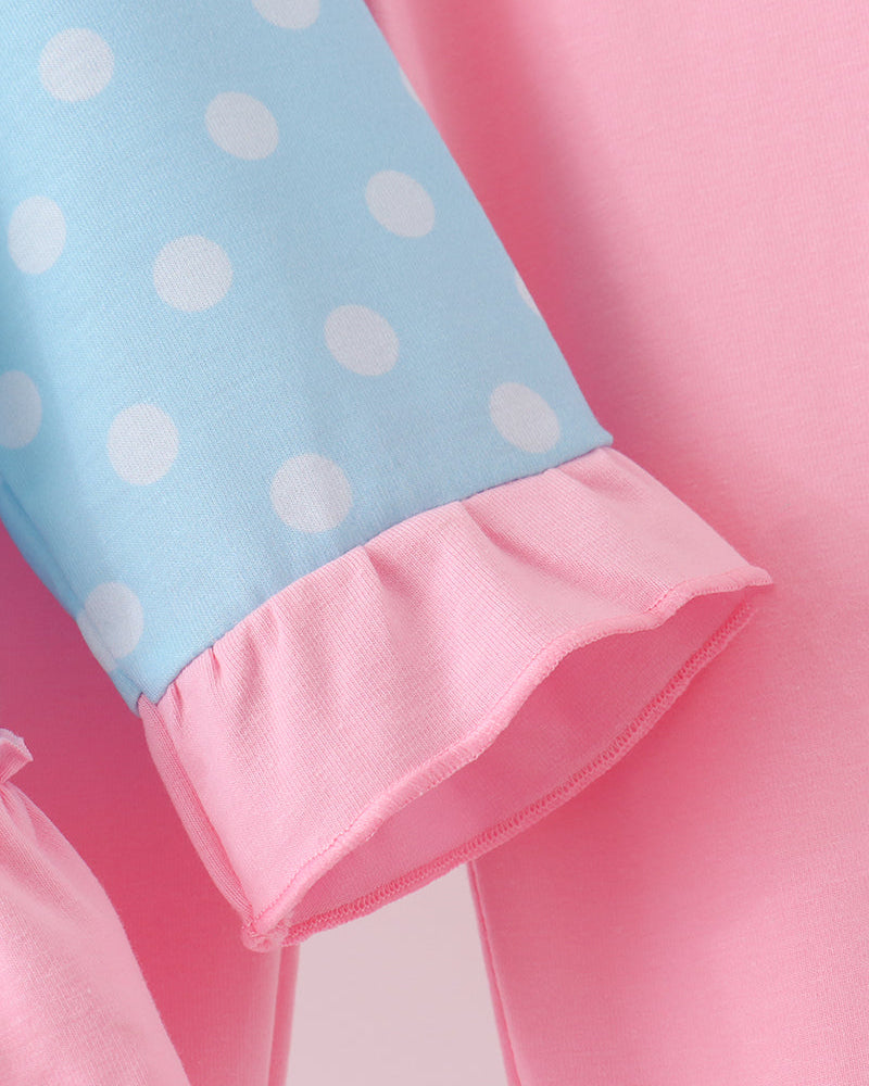 Close-up: light blue sleeve cuff with pink ruffled hem and trim