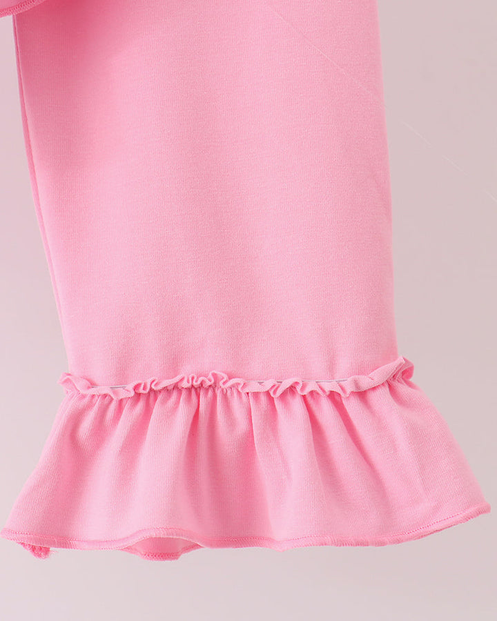 Close-up: pink pants with gathered ruffle hem and ruffled cuff