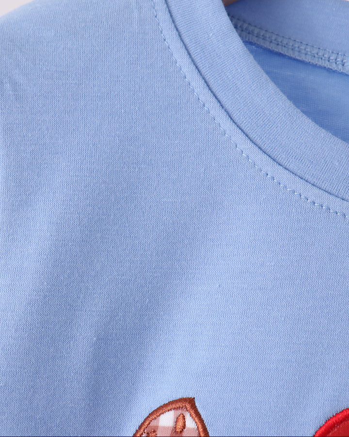 Light blue sweatshirt with crew neck seam and partial Santa cookie embroidery