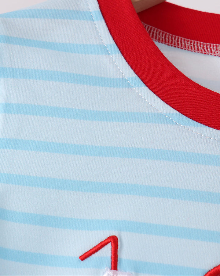 Crew neckline of light blue striped pajama shirt with red trim