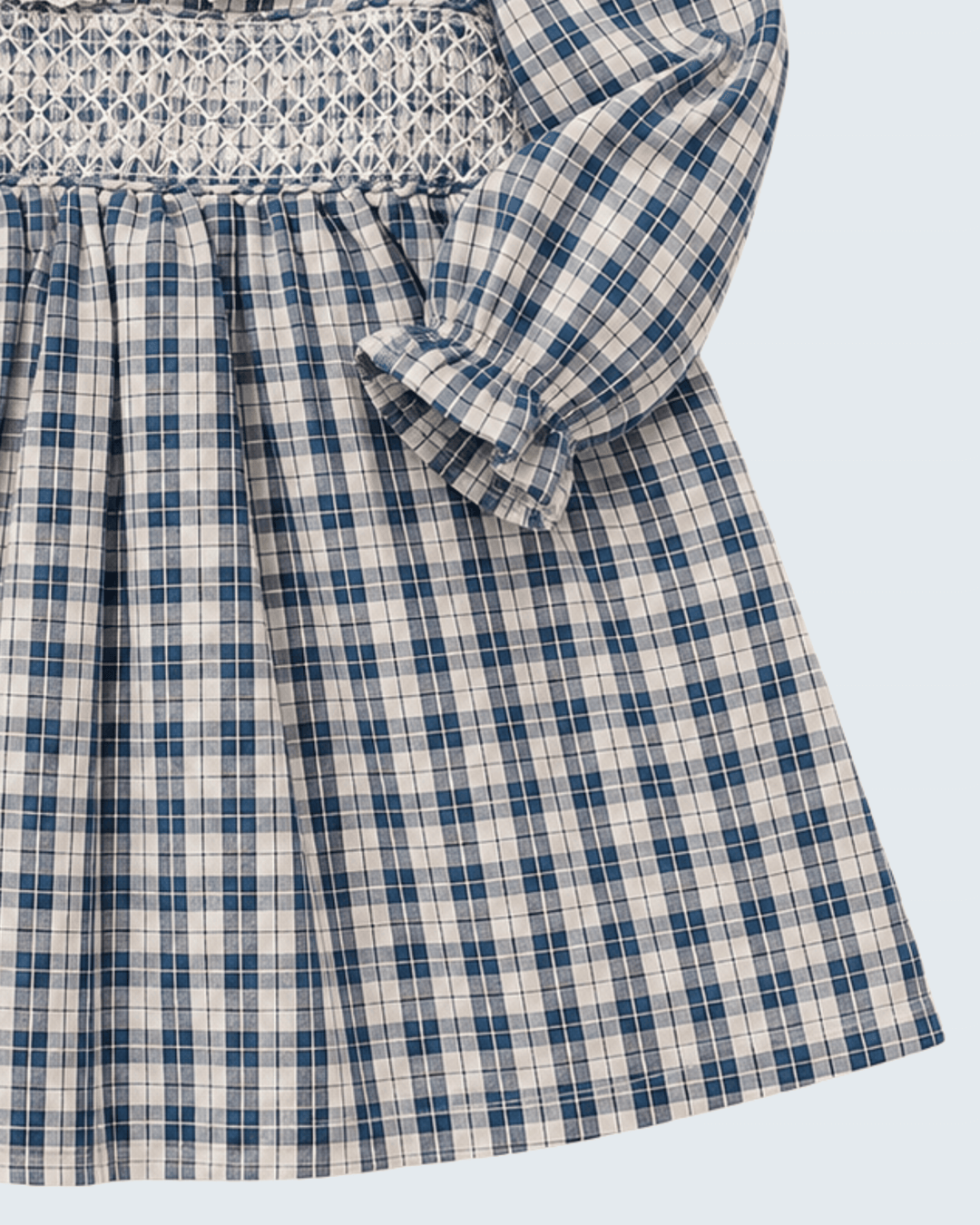 Blue plaid dress close-up: smocked bodice, puff sleeve bow, pleated skirt