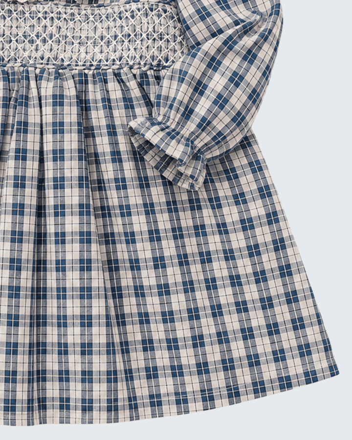 Blue plaid dress close-up: smocked bodice, puff sleeve bow, pleated skirt