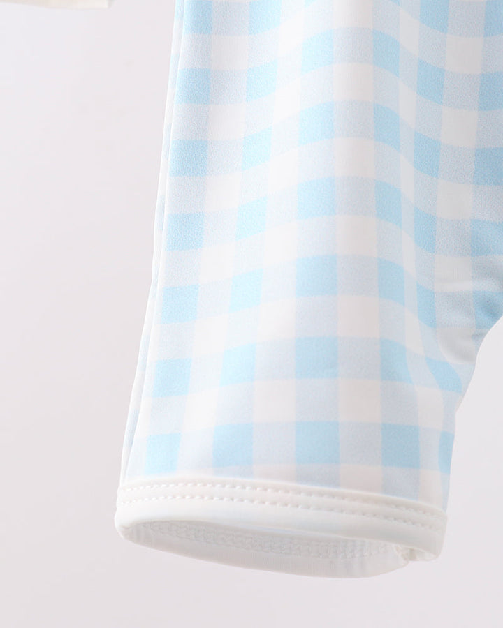 Close-up of a blue and white checkered fabric on a light gray background