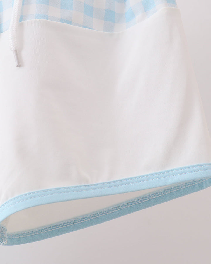 Close-up of a white garment with a light blue trim on a light gray background