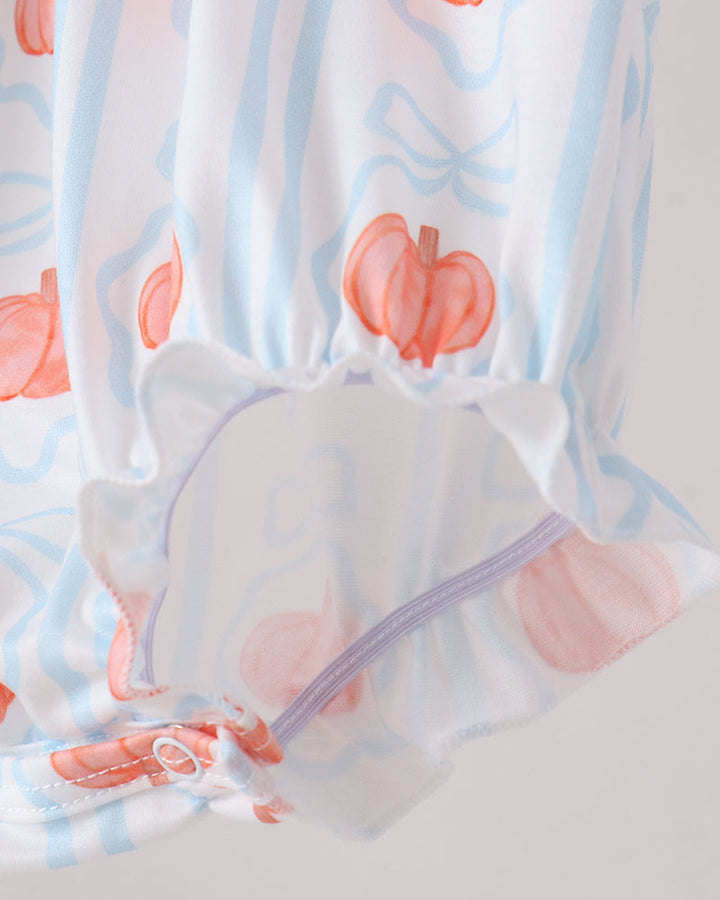 Close-up of a white garment with a light blue vertical stripe pattern, pinkish-orange pumpkin motifs, and a ruffled hem with a lavender elastic band.