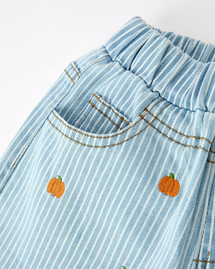 Light blue denim jeans with embroidered pumpkins on a white background