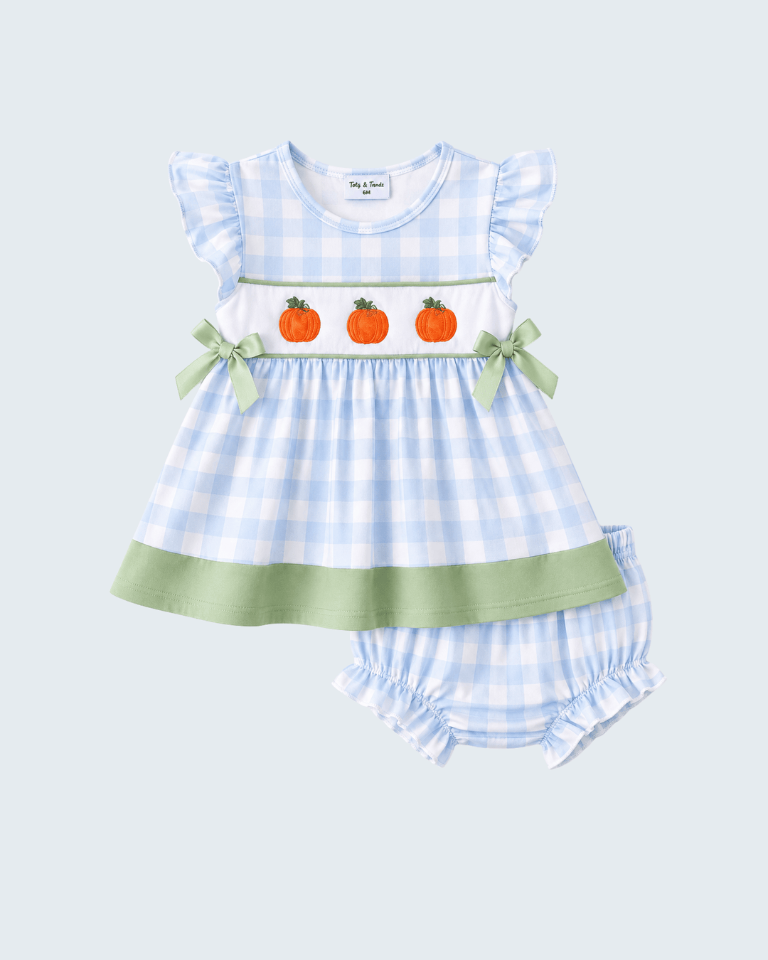 Baby girl's two-piece outfit set featuring a light blue and white gingham dress with three orange pumpkin motifs and green ribbon bows on the chest, paired with matching gingham bloomers.