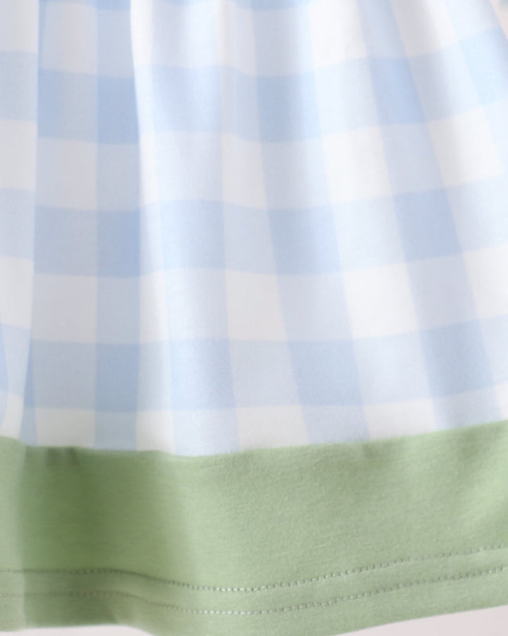 Close-up of a light blue and white gingham fabric with a solid pale green hem band.