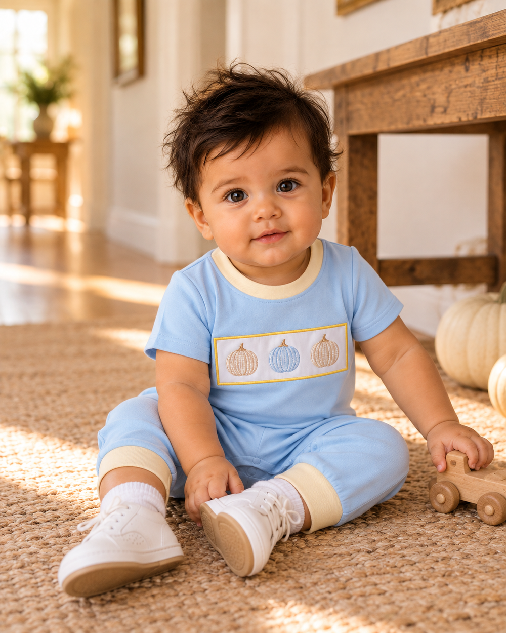 Light blue baby romper with pumpkin embroidery, short sleeves, and footless cuffs