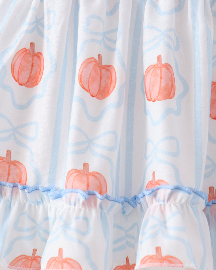 White ruffled dress with a repeating pattern of orange watercolor pumpkins and light blue bow outlines, finished with a ruffled hem.