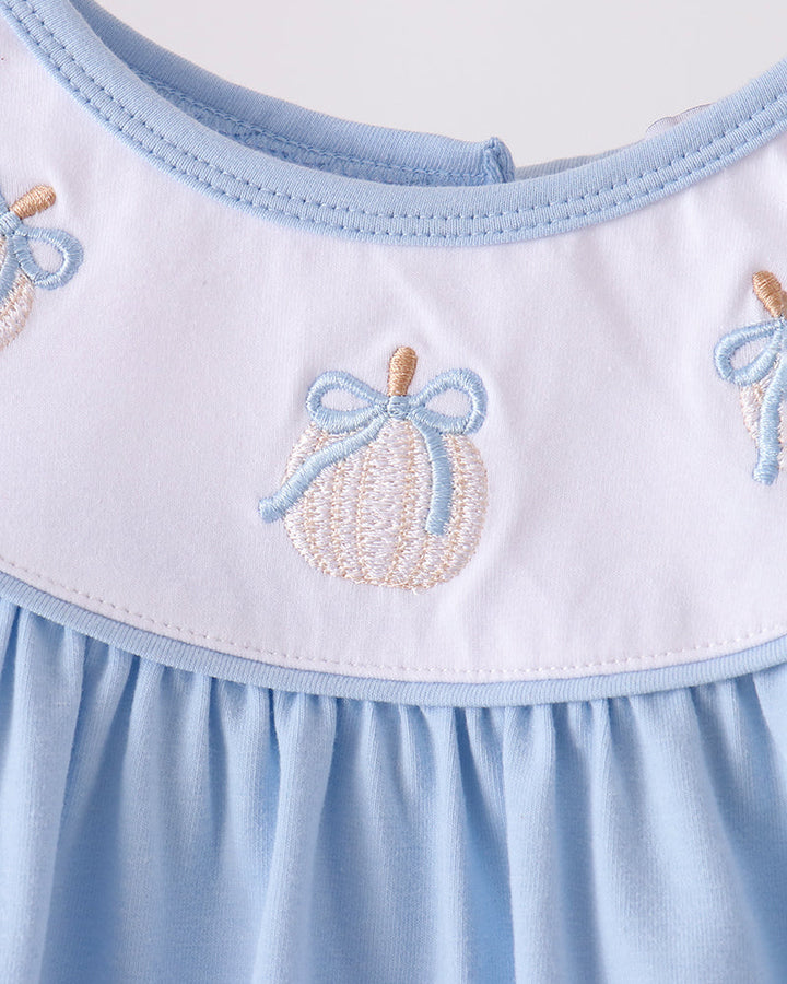 White yoke with light blue ruffle trim and stitched pumpkin embroidery at the neckline