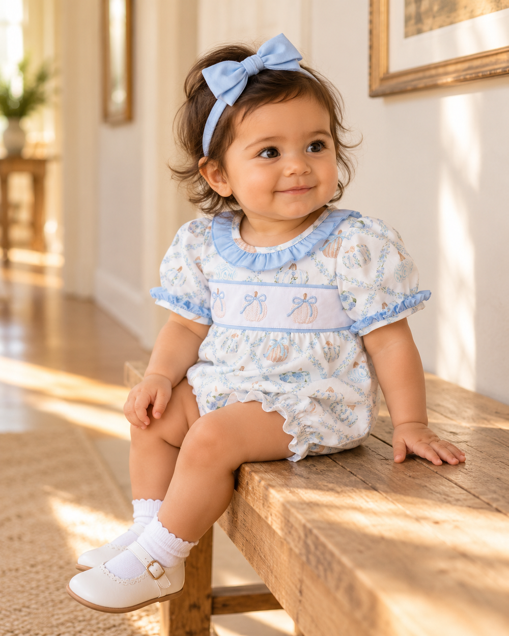 Girls' bubble romper with light-blue bow, ruffled neckline, and embroidered pumpkin print