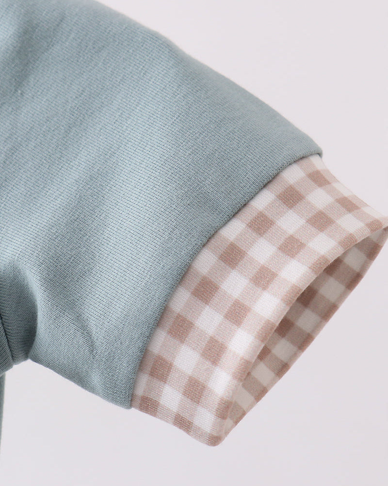 Close up image on sleeve in blue with gingham hem
