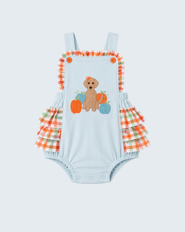 A baby romper in light blue with ruffled orange, green, and white plaid straps and leg bands, featuring an embroidered dog and pumpkins motif on the front.