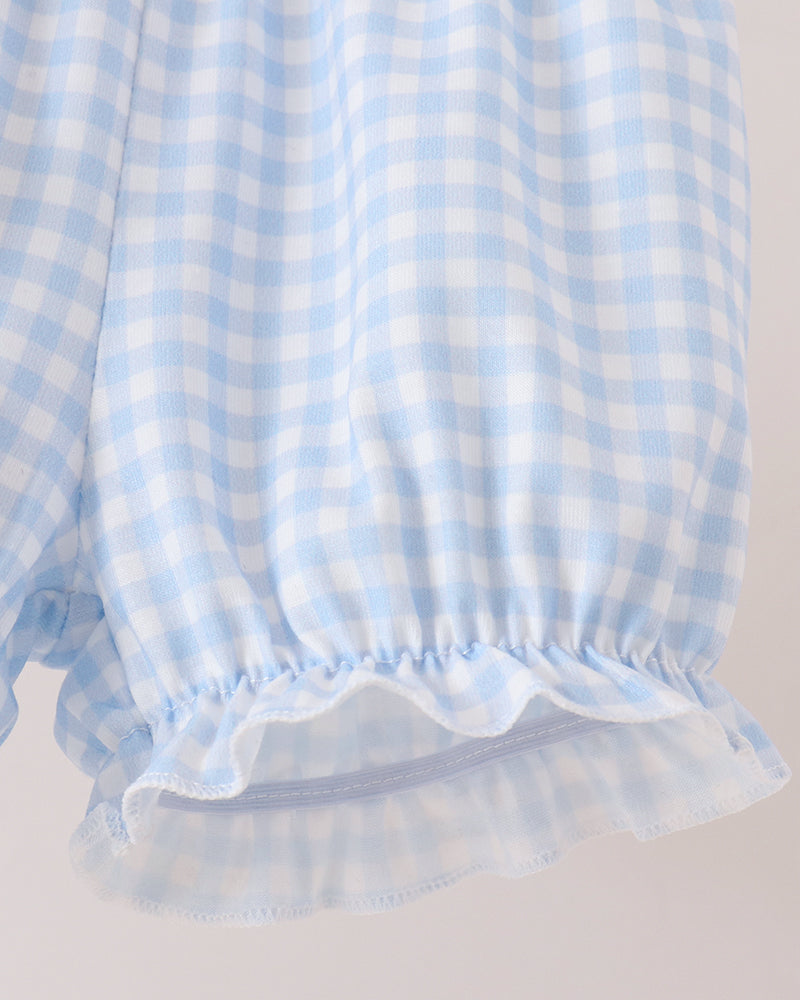 Close-up of a light blue and white gingham check fabric with a ruffled elastic hem, shown against a plain light background.