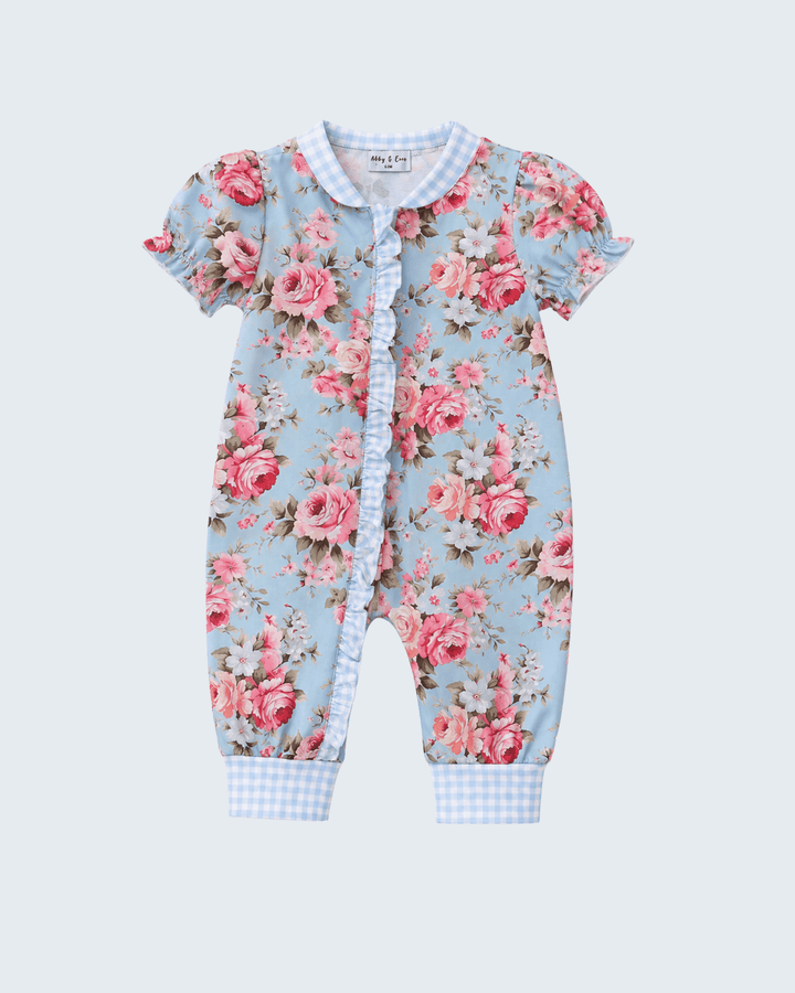 A baby short-sleeve footless romper in a light blue floral print with pink roses, featuring a gingham collar and leg cuffs, and a ruffled snap-button front.