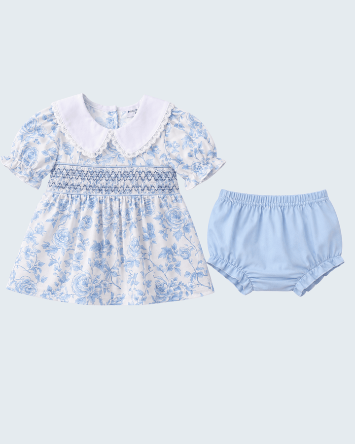 Baby dress with floral pattern and matching bloomers on a light blue background