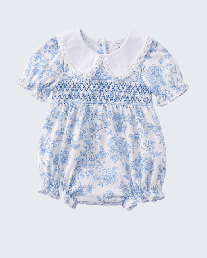Baby romper with blue floral pattern on a light gray background