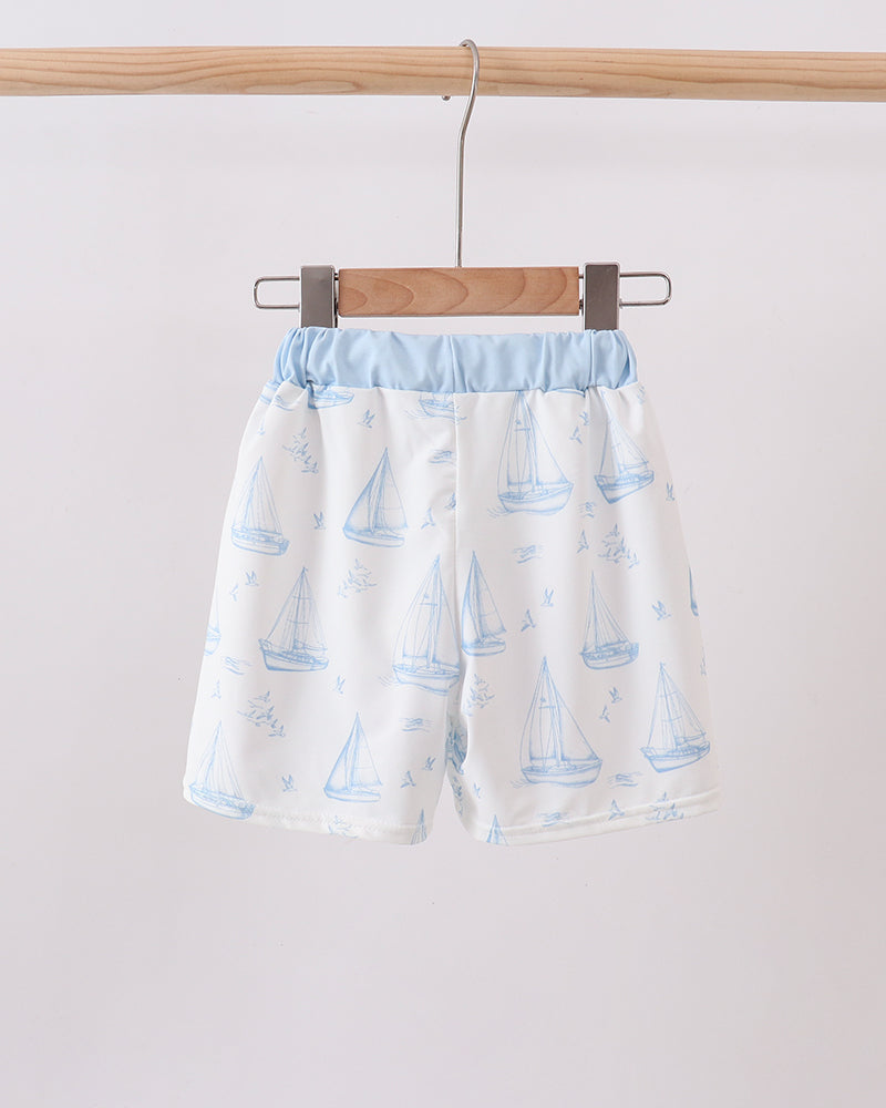 Light blue and white sailboat print swim trunks with elastic waist and drawcord ties