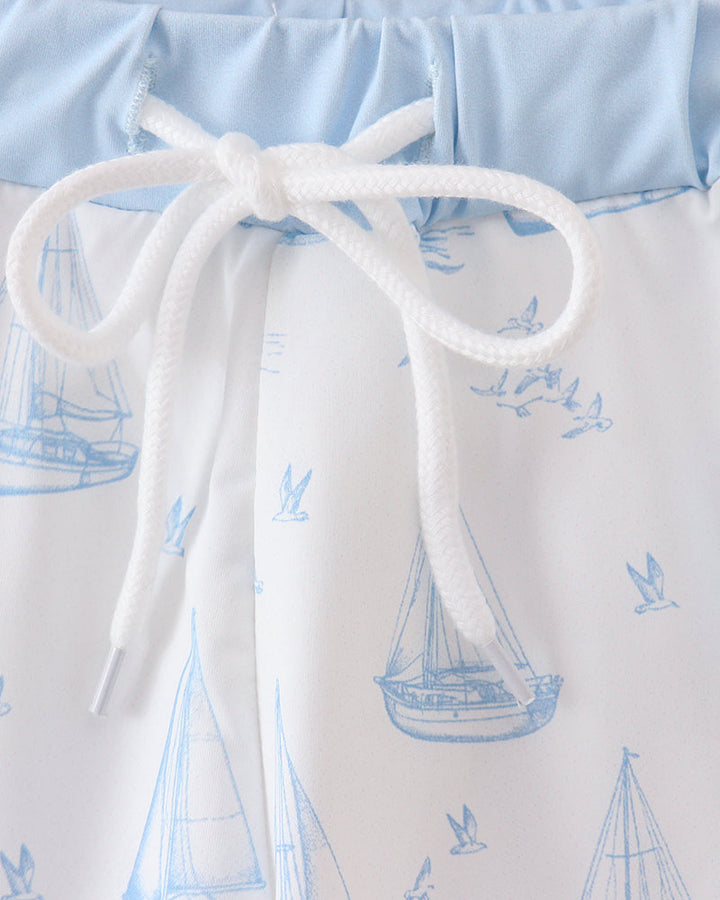 Sailboat print swim trunks with white drawstring and light blue waistband