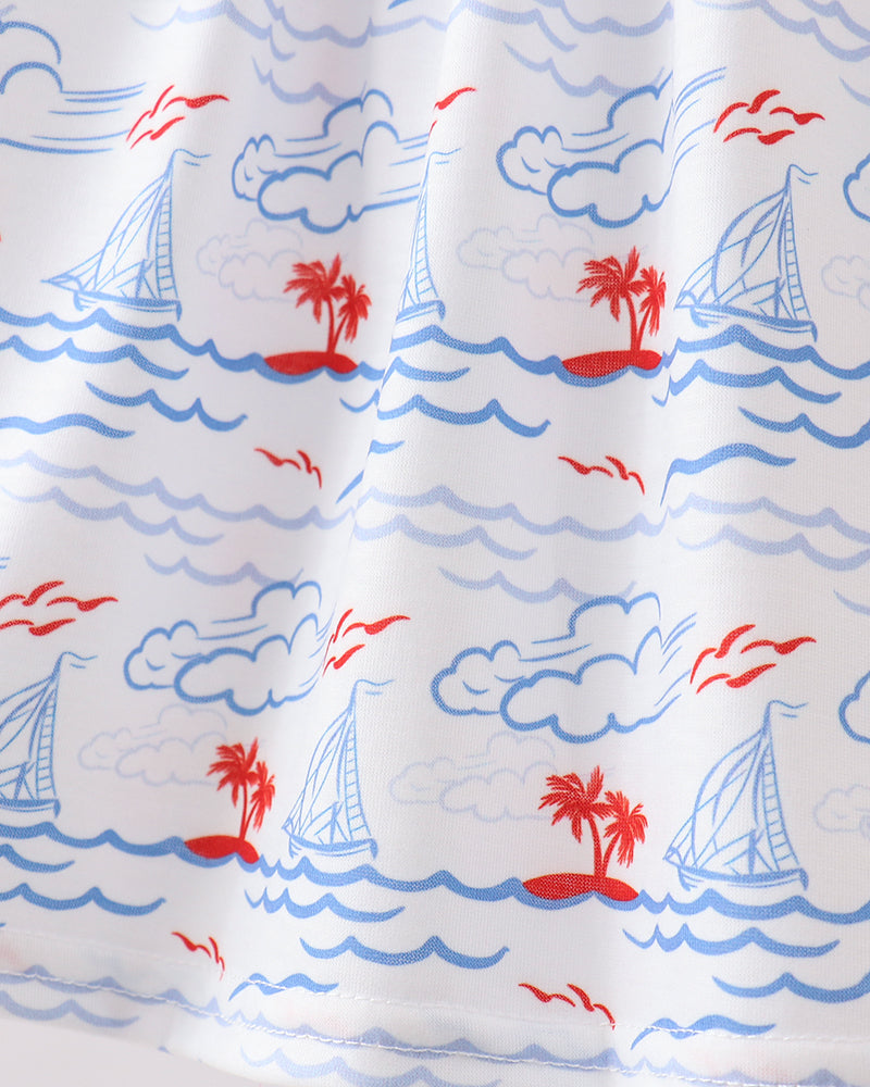 Dress with nautical design featuring sailboats, palm trees, and clouds.