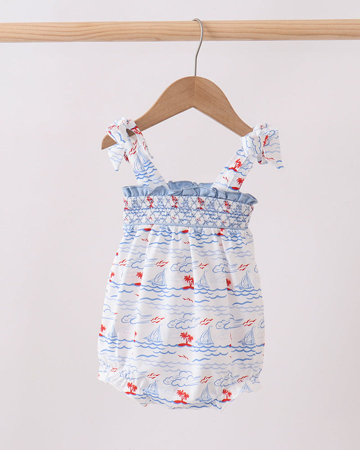 Baby romper with nautical pattern on a wooden hanger against a white background