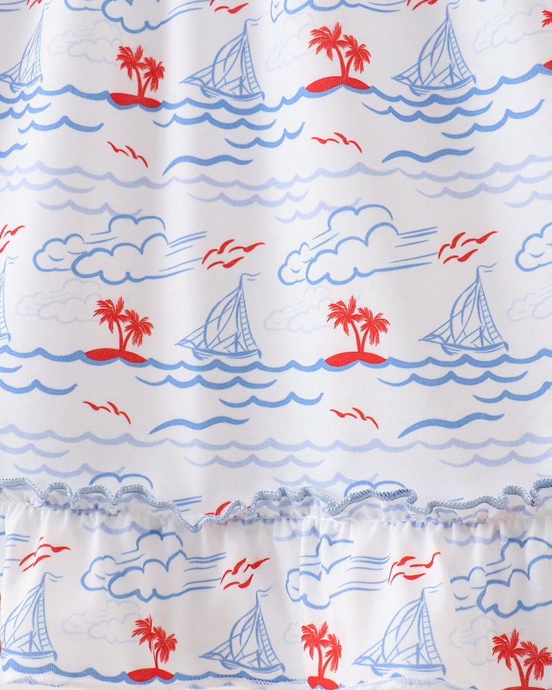 Dress with nautical pattern including palm trees, sailboats, and clouds on a white background
