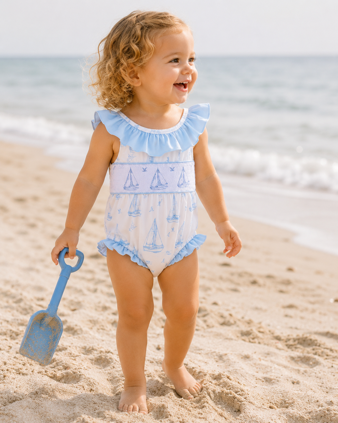 Young girl standing on the beach looking over the ocean