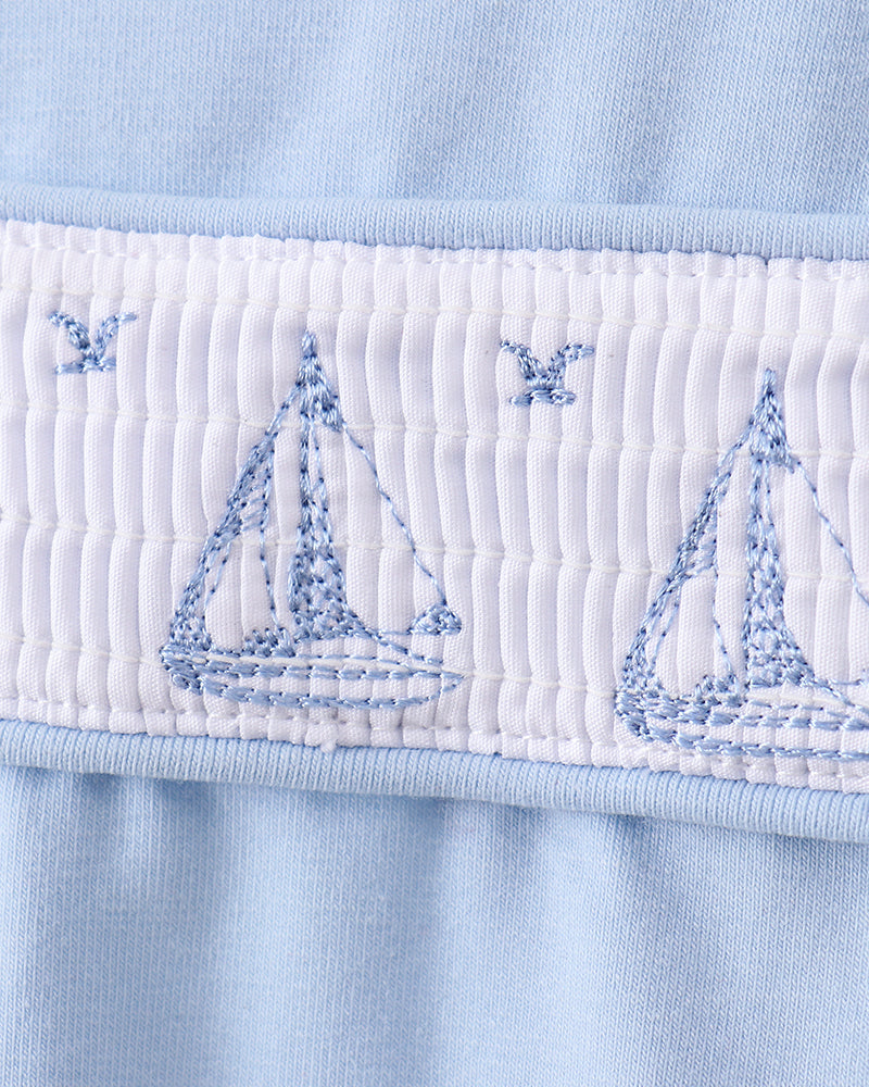 Blue shirt with embroidered sailboats and smocked detailing