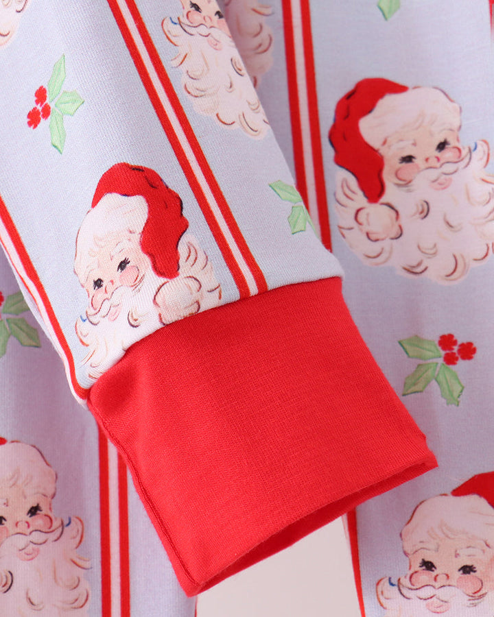 Kids pajama detail: red cuff with white fabric featuring Santa faces and stripe accents
