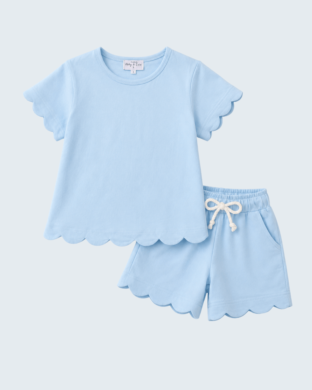 Light blue pajama set with scalloped edges on a light gray background