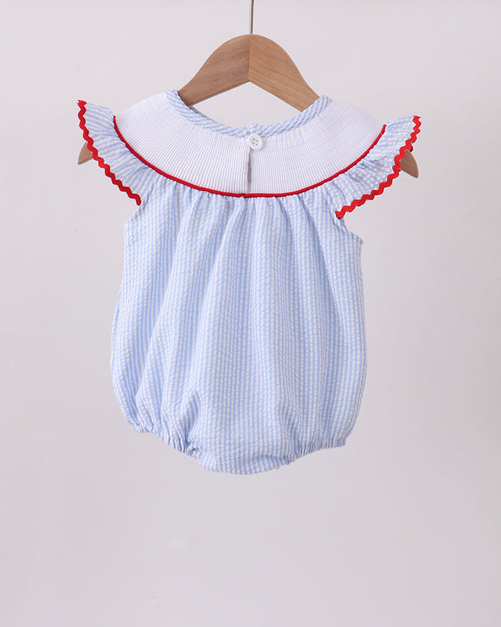 Baby romper with red trim on a wooden hanger against a light background