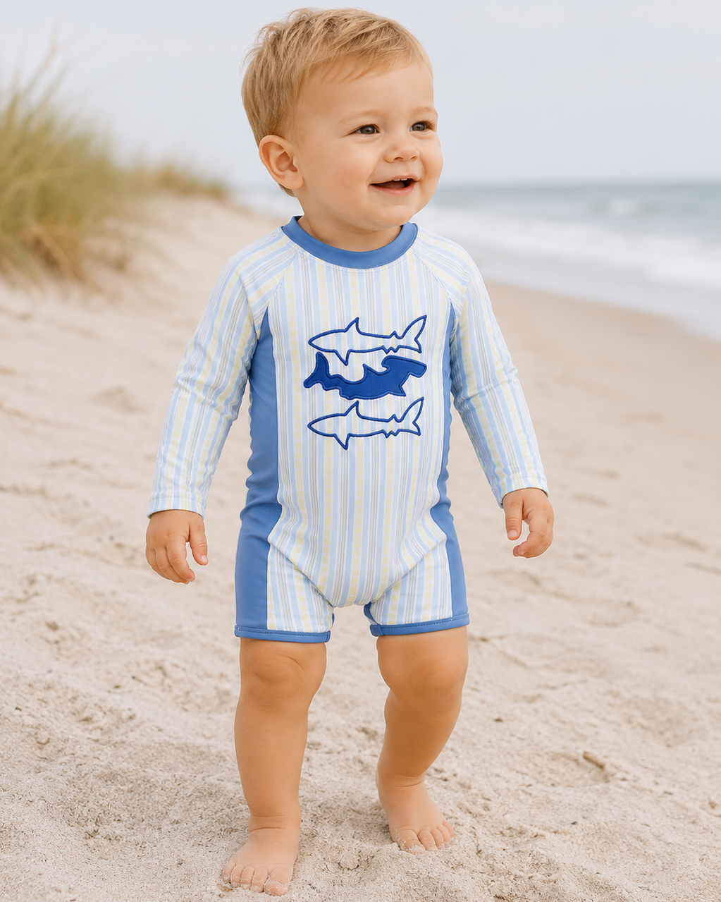 Baby boy on beach wearing Blue Shark Applique Stripe Swimsuit