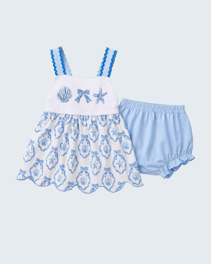 Baby dress and bloomers set with blue and white design on a light blue background