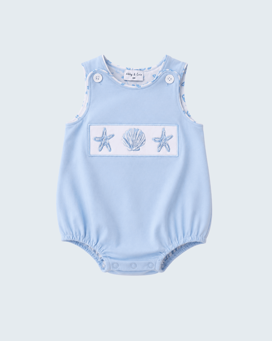 Light blue baby romper with starfish and shell design on a light gray background