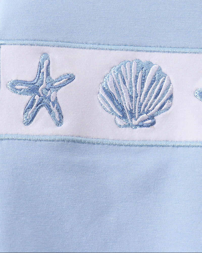 Light blue fabric with embroidered starfish and shell design