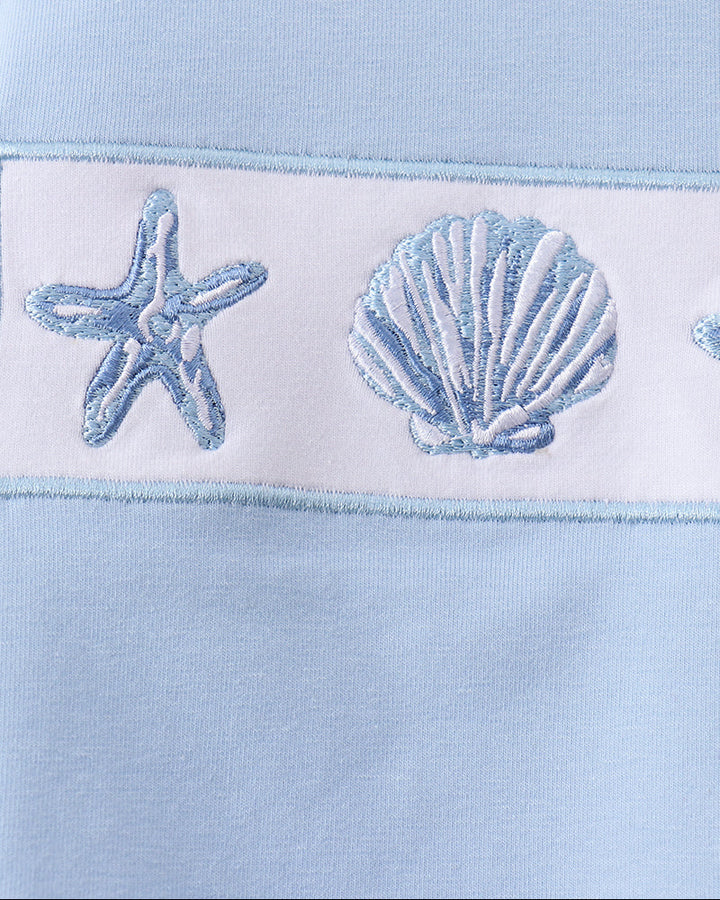 Light blue fabric with embroidered starfish and shell design