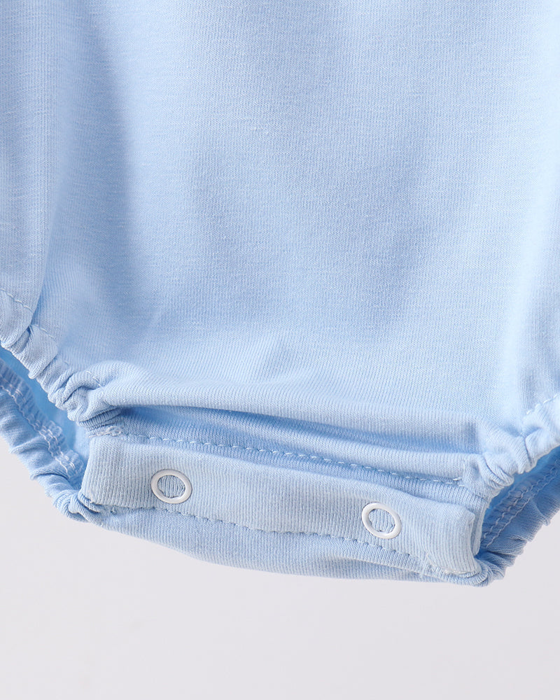 Close-up of a light blue baby romper with button details on a white background